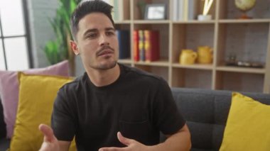 Sakallı, yakışıklı, genç bir İspanyol 'un portresi, rahat bir oturma odasında sohbet ediyor..