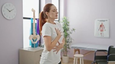 Kızıl saçlı kadın derin nefes alıyor. Huzurlu bir rehabilitasyon kliniğinde. Sağlık ve sağIık duygusu veriyor..