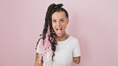 Neşeli İspanyol ampüte kadın pembe izole edilmiş arka planda neşeli, mutlu bir ifadeyle dilini dışarı çıkarıyor.