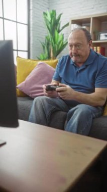 Evde video oyunu oynayan olgun bir adam. Odaklanmış ve rahatlamış..