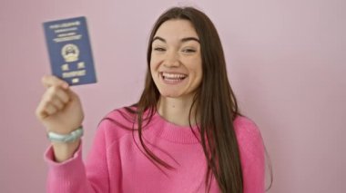 Neşeli genç İspanyol kadın Hong Kong pasaportuyla poz veriyor, parmaklarıyla 