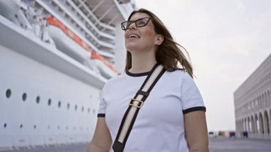 Genç bir kadın lüks bir yolcu gemisinde gülümsüyor, sakin bir deniz yolculuğunu ima ediyor..