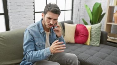 Modern bir dairede telefonuyla strese giren genç bir İspanyol..