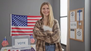 Amerikan seçim koleji odasında kolları çapraz duran kendine güvenen genç bir kadın oy verme kabini ve Amerikan bayraklarıyla 