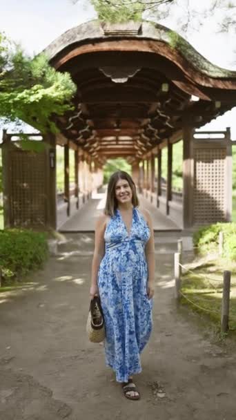 美しいヒスパニックの女性が喜びを放射し 自信を持って立って 日本の伝統的な京都で平安神宮に歩いている間にカメラに微笑みました — ストック動画