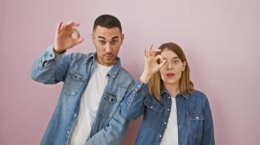 Şaşırtıcı ama kendine güvenen, pembe soyutlanmış arka planda birlikte duran güzel bir çift. Kot gömlek giyiyorlar, parmaklarından bakıyorlar. Tamam jest yapıyorlar, yüzlerine şok kazınıyor.!