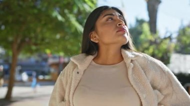 Uzun saçlı tefekkür eden genç bir Hintli kadın şehir caddesinde güneş ışığının tadını çıkarıyor..