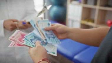 Adam klinikte doktorlara devretmiş. İç mekan ortamında sağlık sigortası ödemelerini tasvir etmiş..