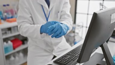 Laboratuvarda güvenlik gözlüğü ve eldiven takıp test tüpünü analiz eden profesyonel bir adam..