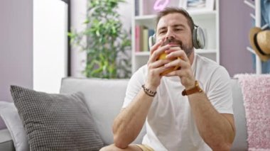 Rahat, orta yaşlı bir adam kulaklıkla müzik dinlemekten ve sıcak bir oturma odasında bardak tutmaktan hoşlanır..