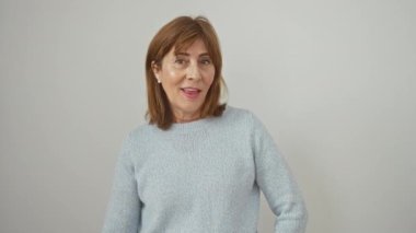 Süveter giymiş mutlu orta yaşlı bir kadın. Kulakları kulaklarında ilginç bir dedikodu dinliyor. Sağırlığın ortasında duymaya can atıyor. beyaz arkaplanda izole.