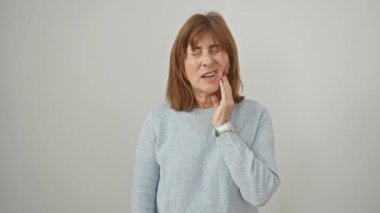 Diş ağrısı, orta yaşlı kadın diş ağrısıyla boğuşuyor, ağız ağrısı çekiyor. Beyaz, kazak giymiş mağdur diş ikilemlerini özetliyor.