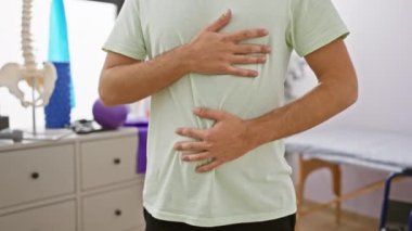 Sakallı beyaz bir adam rehabilitasyon kliniğinde nefes egzersizi yapıyor..