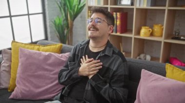 Genç bir İspanyol 'un samimi portresi, gözlükleriyle parıldıyor, evdeki rahat bir kanepede otururken minnetle ışıldıyor. Göğüs göğüse, sağlıklı ve neşeli bir görüntü..