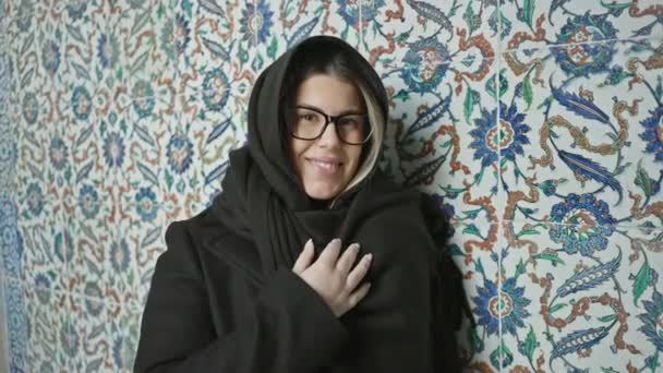 Seorang Wanita Tersenyum Dengan Kacamata Dibungkus Selendang Berpose Melawan Latar — Stok Video