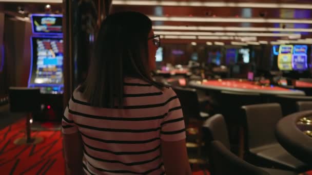 Mujer Morena Pie Casino Con Máquinas Tragamonedas Borrosas Mesas Póquer — Vídeos de Stock