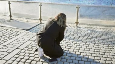 Genç bir kadın Sultanahmet 'te sahil kenarında bir kediyle etkileşime girer ve bir an için şehir sakinliğini gösterir..