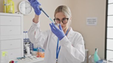 Odaklanmış bir kadın bilim adamı klinik bir ortamda laboratuvar ortamında deneyler yapıyor, araştırma ve sağlık dinamikleri sergiliyor..