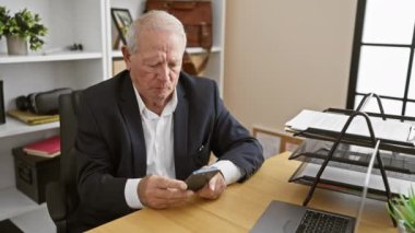 Sinirli kıdemli bir işadamı, stresli bir işçi, ofisteki akıllı telefonuna öfkeyle bir mesaj yazıyor.