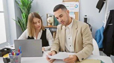 Profesyonel bir erkek ve kadın, modern ofis ortamında belgeleri birlikte inceliyor..