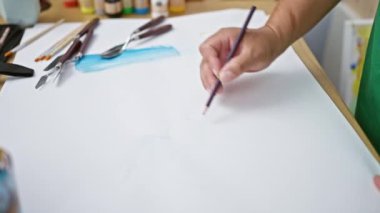 Tutkulu genç Latin ressam, canlı bir sanat stüdyosunun kalbinde yer alan defterine kendini kaptırdı.