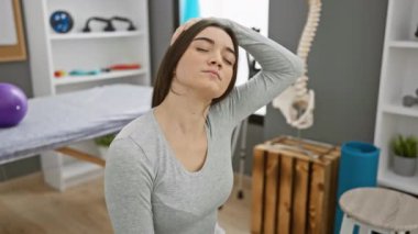 Genç İspanyol kadın rehabilitasyon kliniğinde uzanıyor, sağlık ve sağlık hizmetleri gösteriyor..