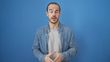 Kel, sakallı, kot gömlek giyen bir adamın portresi.