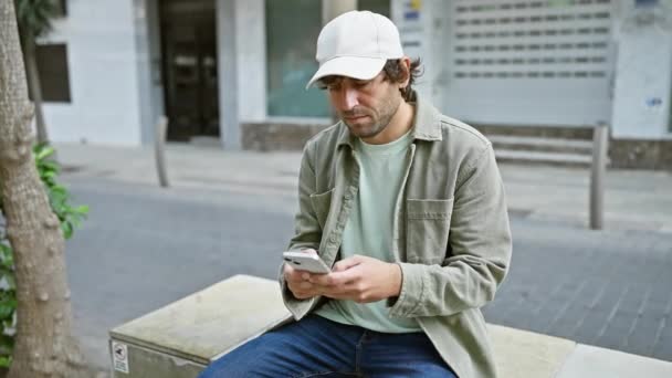 Şapka Ceket Giyen Yakışıklı Genç Adam Şehir Bankında Otururken Akıllı — Stok video