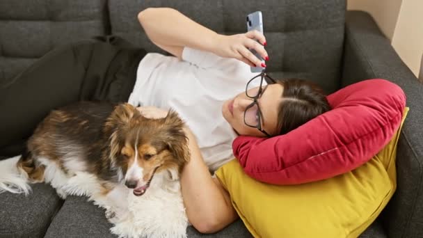 Uma Mulher Relaxada Óculos Cão Descansando Sofá Com Smartphone Dentro — Vídeo de Stock