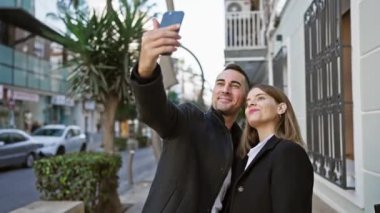 Bir çift şehir sokaklarında birlikte selfie çekiyor, açık hava ortamında aşkı ve bağlantıyı resmediyorlar..