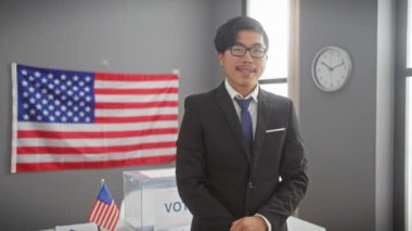 Takım elbiseli genç Asyalı bir adam oy kullanma merkezinde 