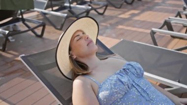 Rahat bir kadın yolcu gemisinde gün ışığının tadını çıkarıyor, boş zamanlarını, seyahatleri ve tatil havasını somutlaştırıyor..