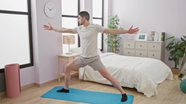Bir adam yatak odasında yoga yapıyor, sağlık ve sükunet yayıyor..