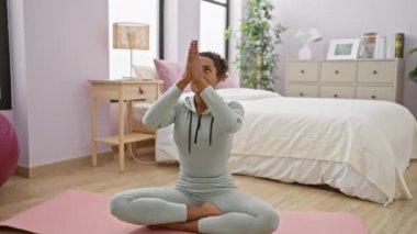Genç bir kadın yatak odasında yoga yapıyor, refahı ve sağlıklı yaşam tarzını örnek alıyor..
