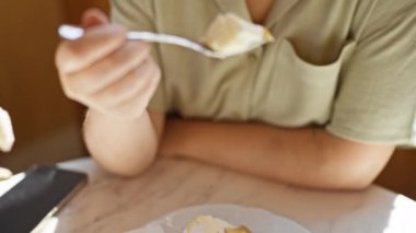 Kafede tatlı yiyen güzel genç bir kadın. 