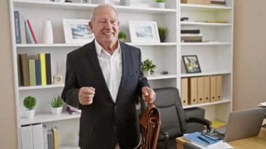 Neşeli kıdemli, kır saçlı, başarılı iş adamı ofiste müzik eşliğinde dans eden, evrak çantasıyla kendinden emin, olgun bir işçinin kazanması iş yerinde eğlence getirir, neşeli bir işçinin portresi..