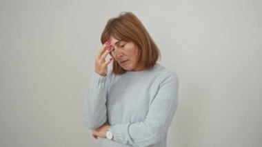 Stres, ayakta durmaktan, gözlerini ovuşturmaktan, burun dokundurmaktan, kazak giymekten yorgun düşmüş orta yaşlı kadın, beyaz izole arka planda baş ağrısı ile boğuşuyor.