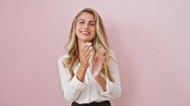 Neşeli genç sarışın kadın sevinçle alkışlıyor, parlak gülümsüyor, pembe izole edilmiş arka planda gururla duruyor tişörtünü giyiyor - mutluluğun başarıyla kutlanışı.!