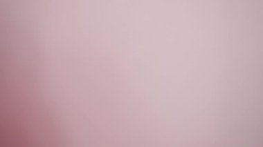 Bir kadının eli pembe arka planda Peru para birimini gösterir.