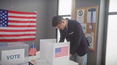 Amerika Birleşik Devletleri oy kullanma merkezinde arka planda Amerikan bayrağı olan genç bir İspanyol oy veriyor..