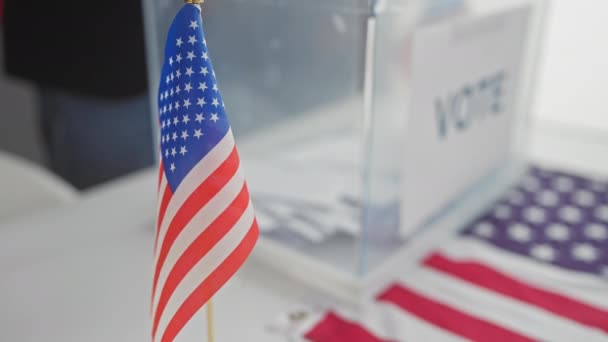在有更多国旗的选举中心 在模糊的投票箱前面的美国国旗 — 图库视频影像