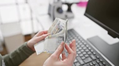 Bir kadın ofis ortamında Perulu tabanları sayarak ticaret ya da bütçe aktivitesi öneriyor.