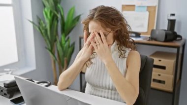 Yürek burkan manzara, ofiste genç, güzel bir kadın, elleri umutsuzca gözyaşları içinde yüzünü kapatıyor - depresyonu gizleyemiyor..