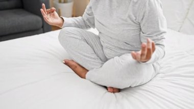 Orta yaşlı İspanyol kadın huzurlu yatak odasında meditasyon yapıyor, evdeki huzuru ve huzuru resmediyor..