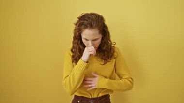Çekici genç bir kadın, sarı arka planda yalnız duruyor, soğuk algınlığından veya bronşitten öksürüyor. Sağlık durumu kritik. Sert astımlı bir öksürük, sağlıksız olduğunun kesin bir işareti..