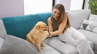 Kendine güveni tam, İspanyol bir kadın. Eğlenceli bir kahkaha atıyor. Evcil köpeğine sarılıyor..