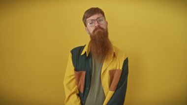 Genç, gözlüklü, kızıl saçlı, ciddi ciddi kameraya bakıyor. Saf sarı bir arka planda, sade bir tişörtle güvenle dikiliyorum..