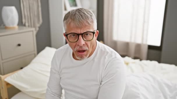 Şüpheli Gri Saçlı Orta Yaşlı Şokta Yatak Odasında Pijama Giyiyor — Stok video