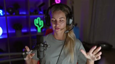 Geceleri neon ışıklı oyun odasında kulaklık ve mikrofonlu genç bir kadın..