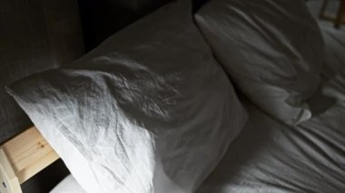 Huzurlu bir kadın, loş bir yatak odasında huzur içinde uyur. Sakinlik ve rahatlama hissi uyandırır..